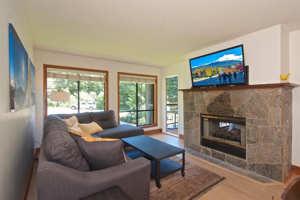 sala de estar con sofá y chimenea en Powderhorn by Whistler Blackcomb Vacation Rentals, en Whistler