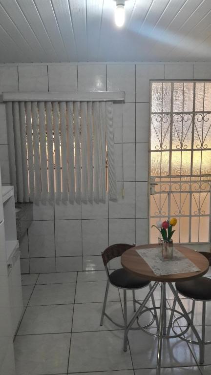 comedor con mesa, sillas y ventana en Apartamento temporário Vila Yolanda, en Foz do Iguaçu