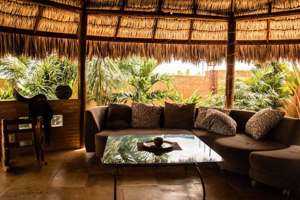 a living room with a couch and a table at Casa do Jardim in Canoa Quebrada
