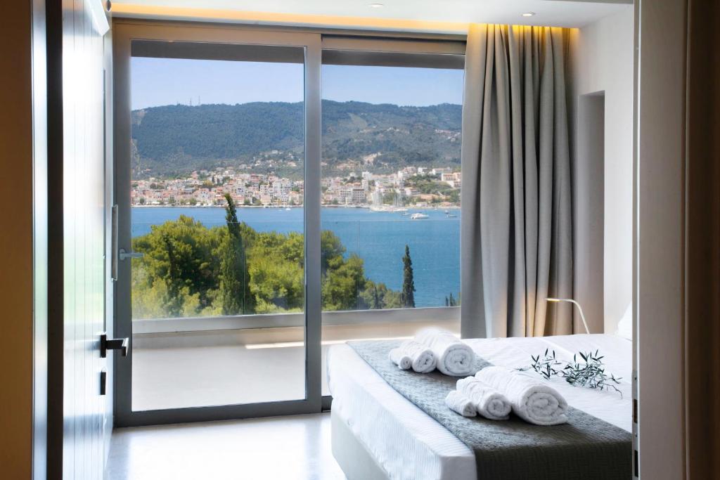 a bedroom with a large window with a view of the ocean at Core Luxury Suites in Skiathos