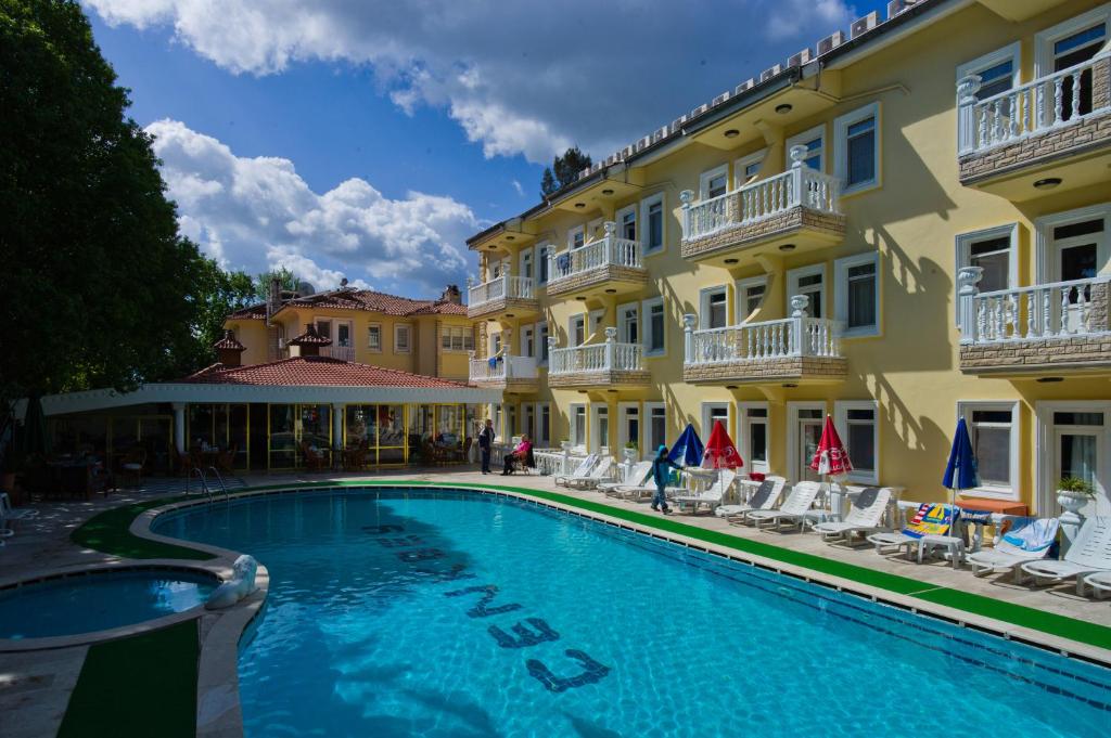 a hotel with a swimming pool in front of a building at Cenk Bey Hotel in Fethiye