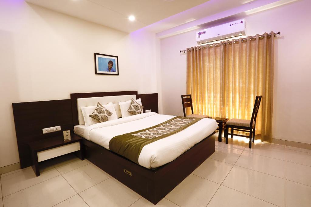 
a bedroom with a large bed and a large window at Hotel Fortune Plaza in Ajmer
