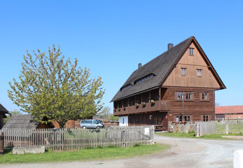 un granero de madera grande con una valla delante en Apartmán ve Skanzenu en Třebechovice pod Orebem