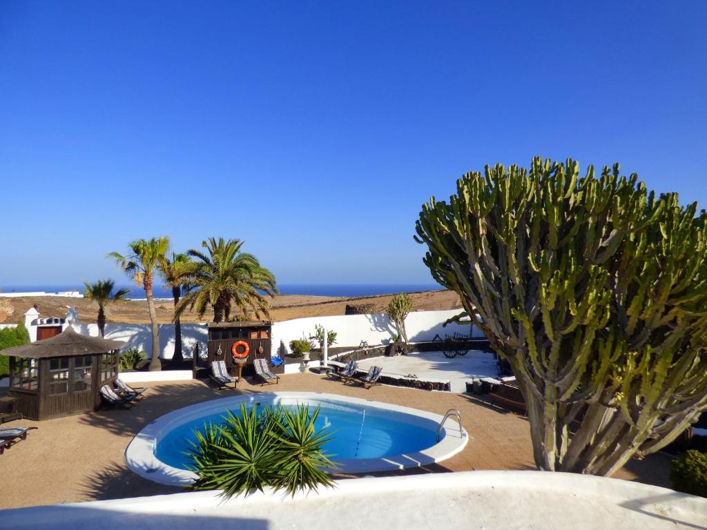 una piscina al centro di un resort con palme di Casa Berriel 2 a Tías