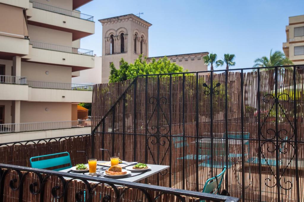 una mesa con 2 platos de comida en el balcón en Ten Hostel en Ibiza