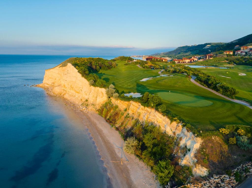 an aerial view of a golf course and the ocean at Thracian Cliffs Golf & Beach Resort in Kavarna