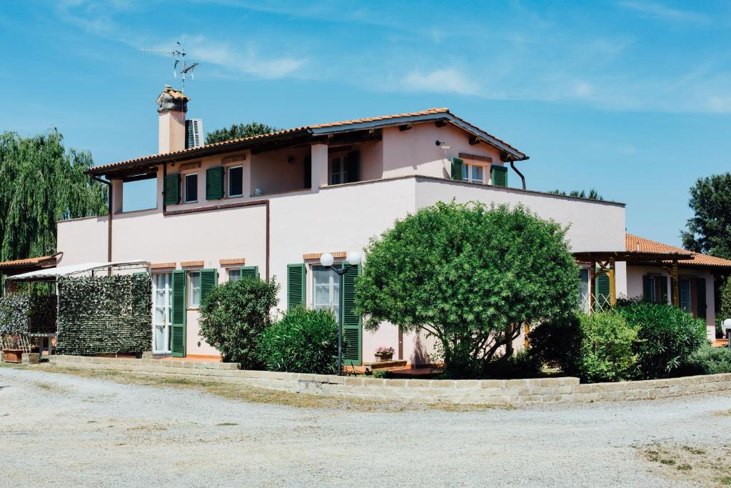 ein weißes Haus mit einem Baum davor in der Unterkunft Agriturismo La Quercia in SantʼAntonio