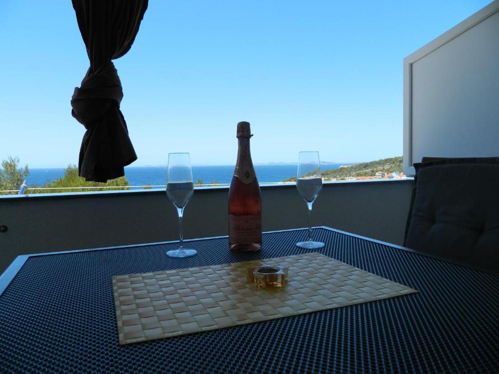 - une table avec une bouteille de vin et deux verres dans l'établissement Apartmani Petra, à Primošten