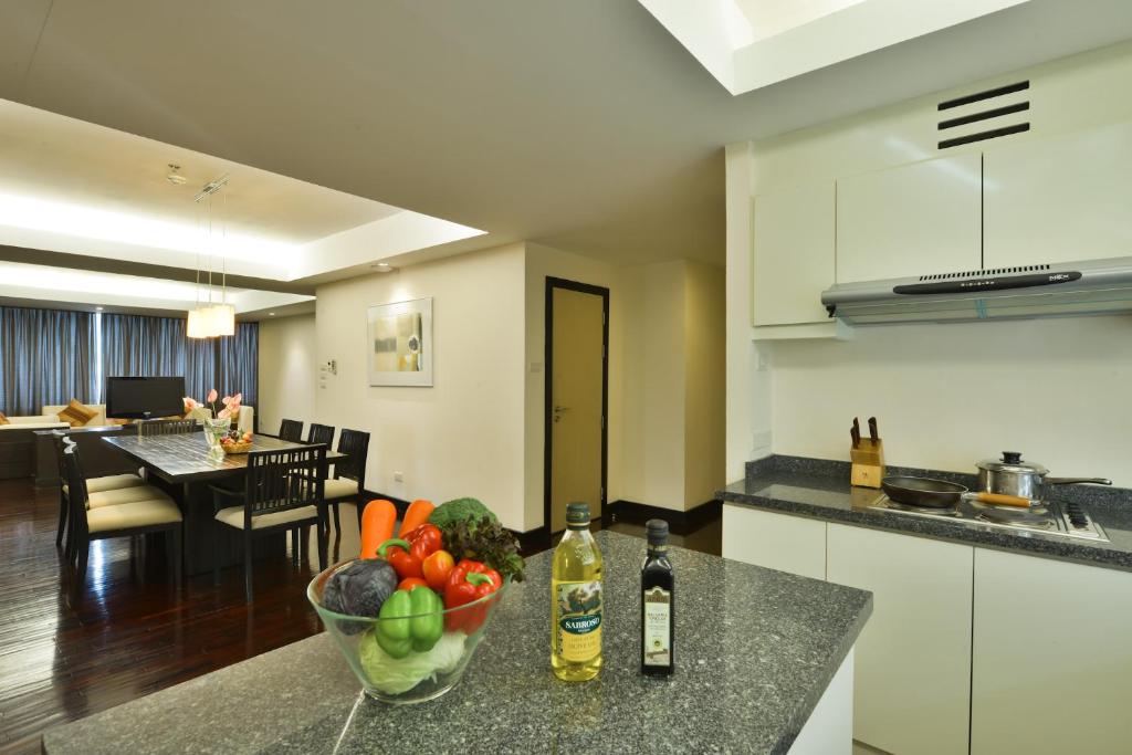 A kitchen-and-dining view with a granite island, cooking appliances, and table beyond.