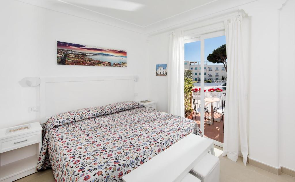 a white bedroom with a bed and a balcony at Villa Pollio Guest House in Anacapri