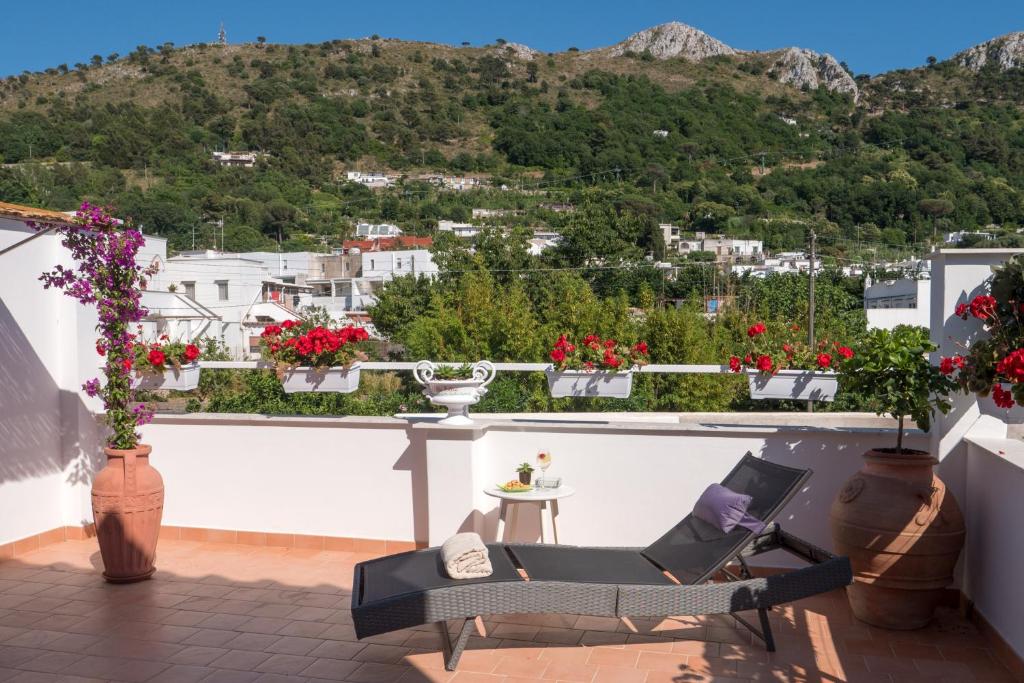 a balcony with a chair and a view of a city at Villa Pollio Guest House in Anacapri
