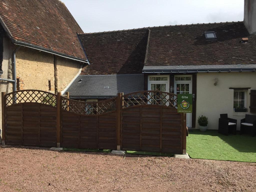 a wooden fence in front of a house at la bonbonniere in Saunay