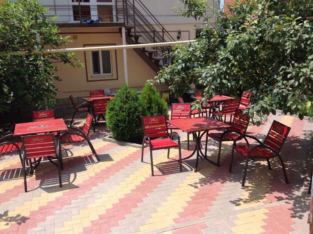 a group of red tables and chairs on a patio at Максим in Gelendzhik