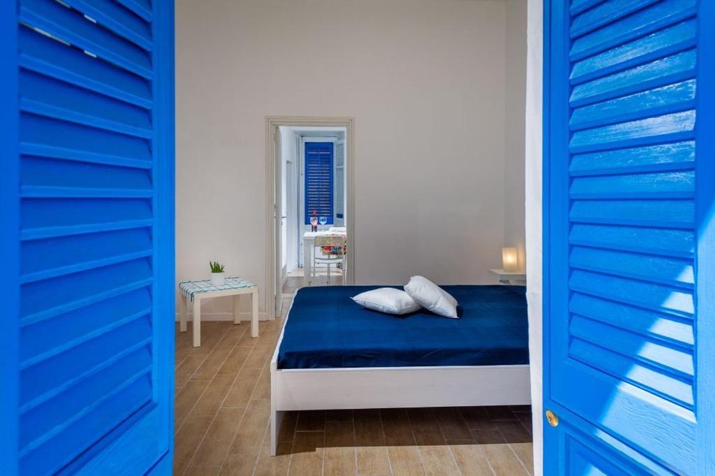 a bedroom with a blue door and a bed with two pillows at Giulia's place-Locazione Turistica in Castellammare del Golfo