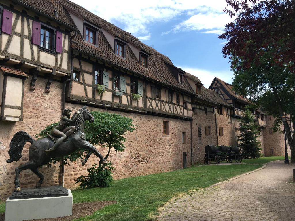a statue of a man riding a horse in front of a building at Apartment Cali Elina in Riquewihr