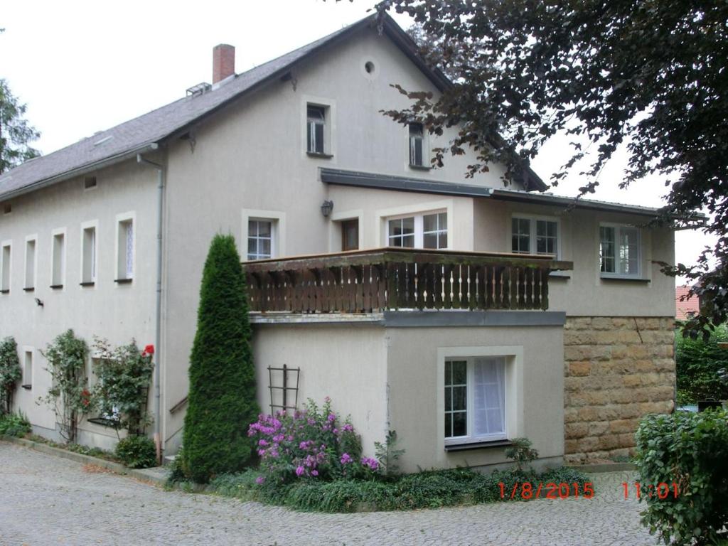 Casa blanca con balcón en la parte superior. en Bauernhof Welde Fewo "Falkennest", en Reinhardtsdorf