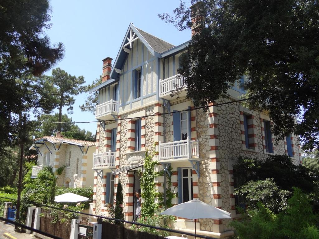 un bâtiment avec un parasol devant lui dans l'établissement Villa Frivole, à Saint-Palais-sur-Mer