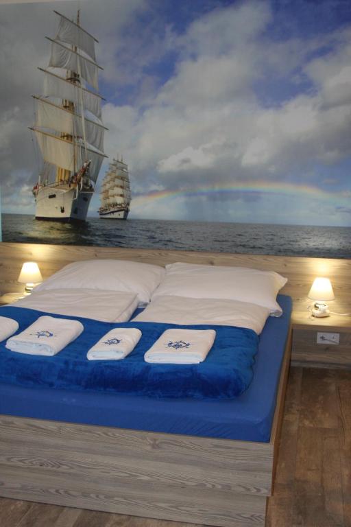 a bed with towels on it in front of a ship at Willa Pod Zaglami in Ustka