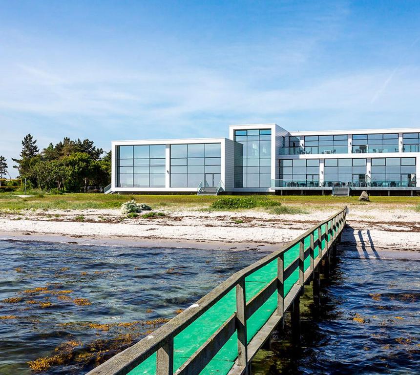 a building on the beach next to a body of water at Storebælt Sinatur Hotel & Konference in Nyborg