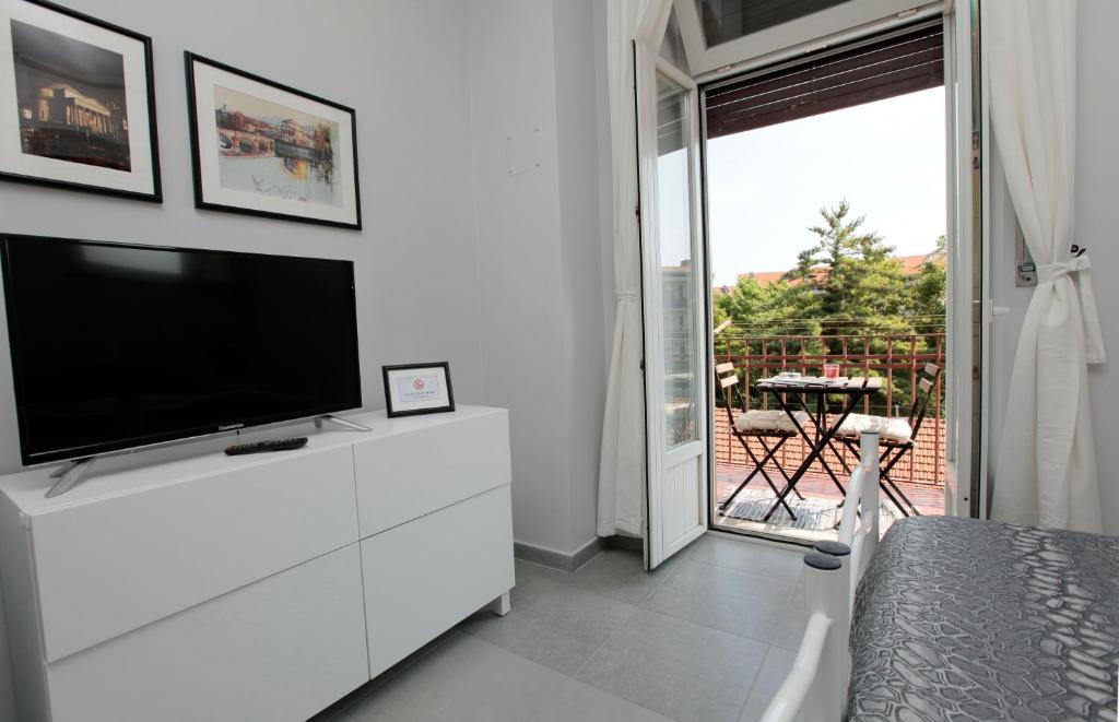 都靈的住宿－Albergo San Maurizio，一间客厅,客厅内配有白色梳妆台上的电视