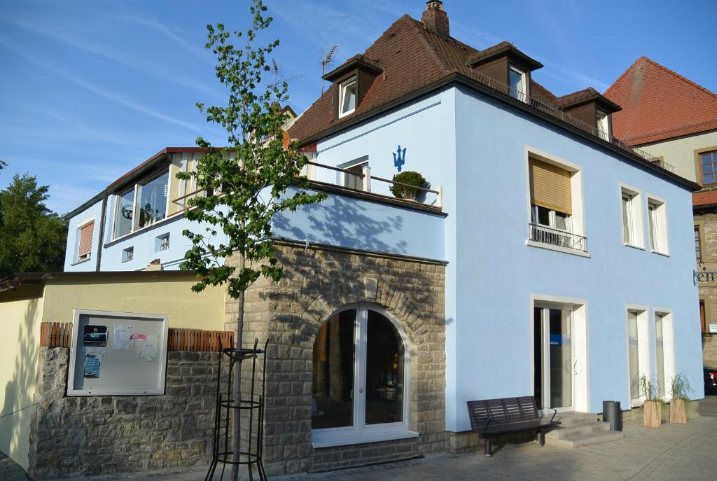 a white building with a brown roof at Ferienwohnung Storchennest in Volkach