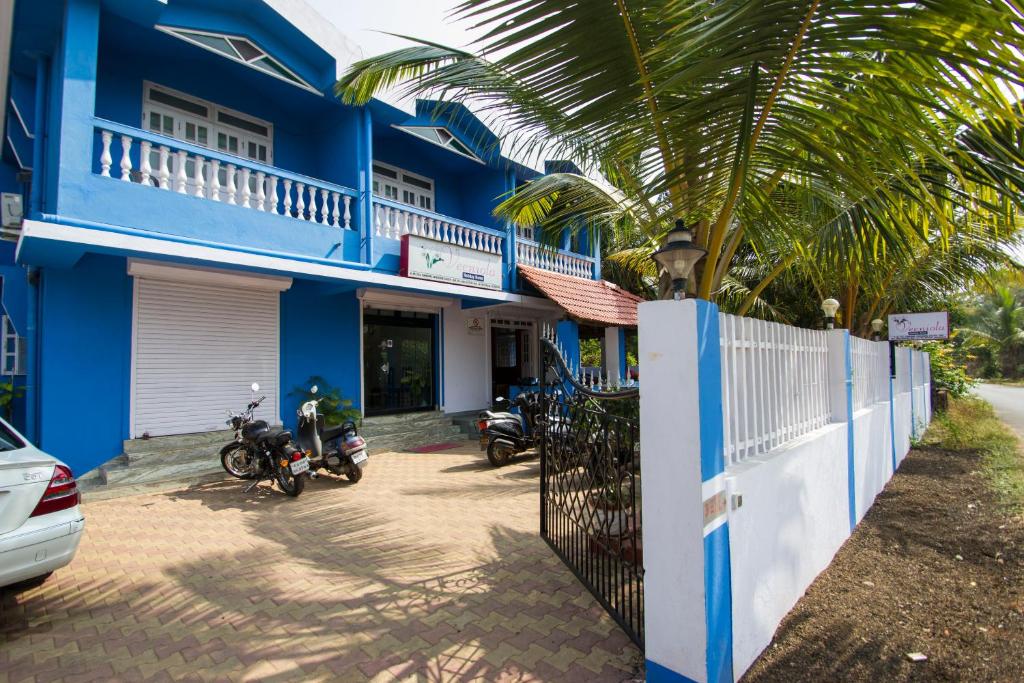 een blauw huis met motoren geparkeerd voor het bij Veeniola Holiday Home in Cavelossim