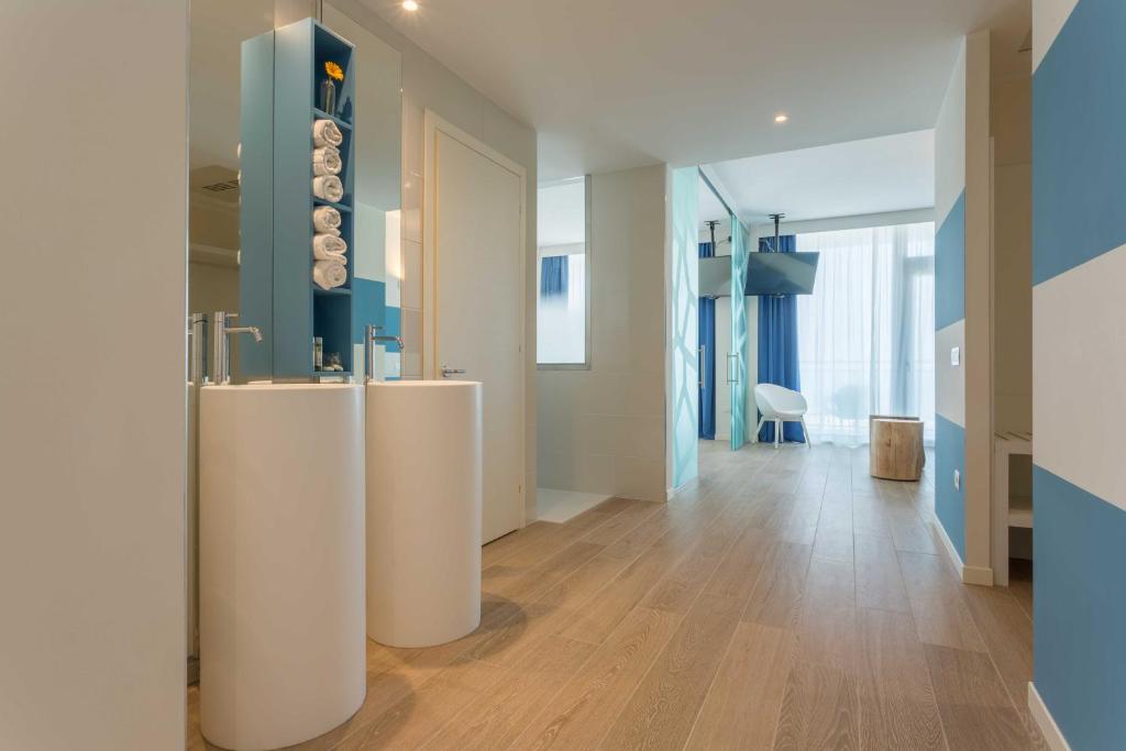a hallway with two white tables in a room at Hotel Mediterraneo in Sottomarina
