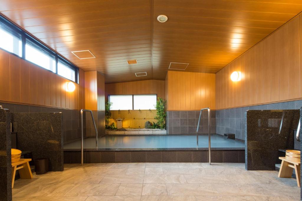 basen w środku budynku w obiekcie Sanco Inn Iseshi-Ekimae Shikinoyu w mieście Ise