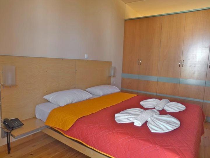 a bedroom with a large bed with towels on it at Sorta Apartments in Kato Daratso