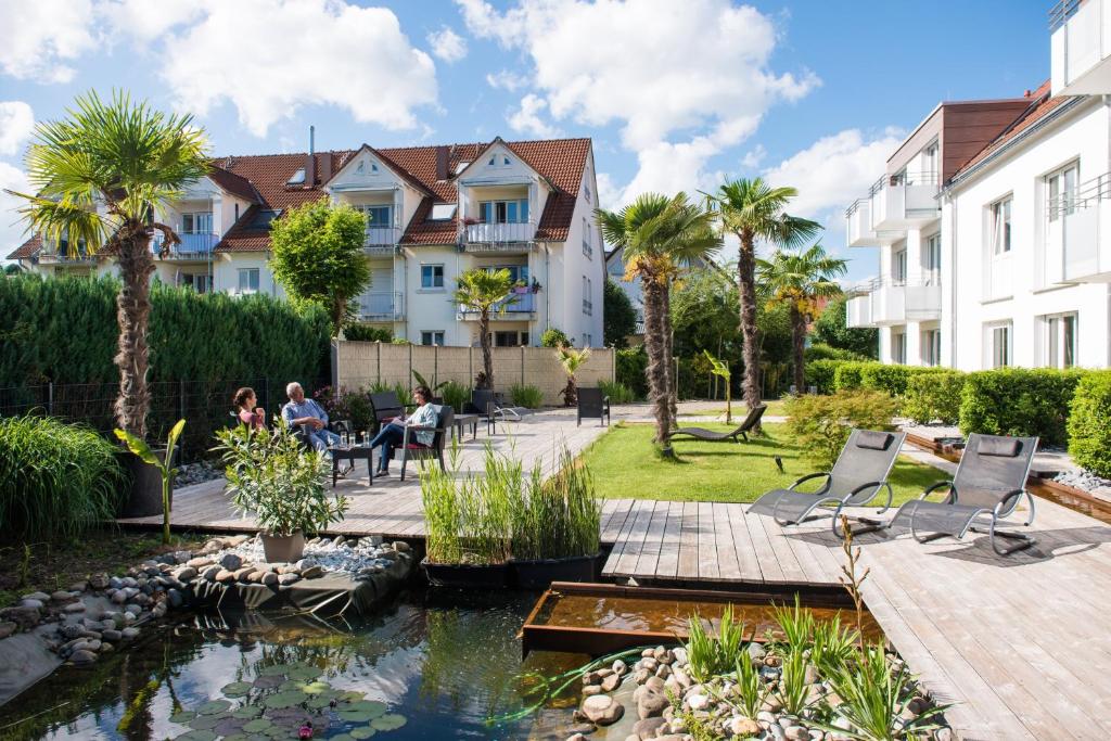 een tuin met een vijver en gebouwen bij Hotel Volapük in Konstanz