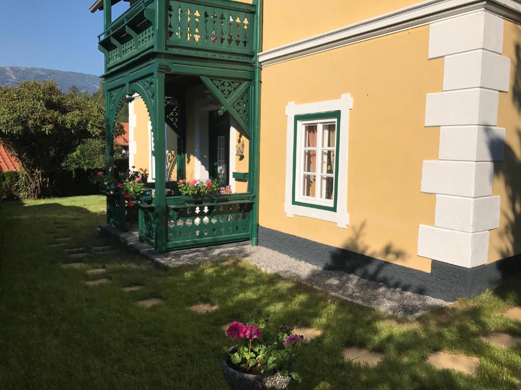 a green and yellow house with flowers in a yard at Haus Thalhammer in Seeboden