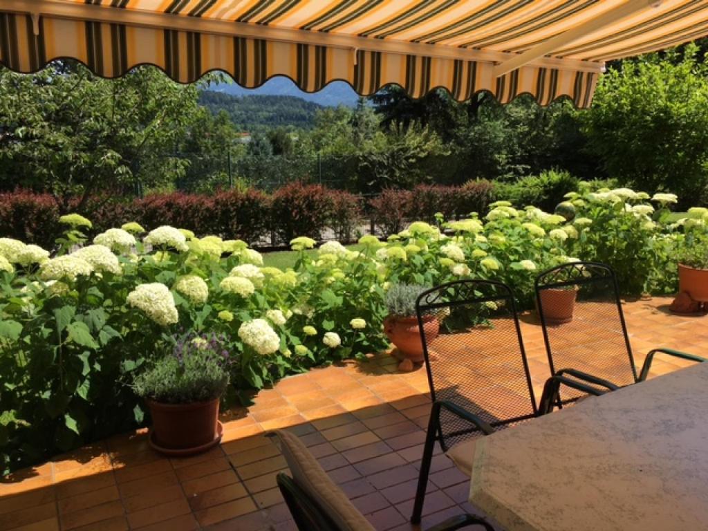 a patio with a bunch of flowers in a garden at Ferienwohnung Fritz in Villach