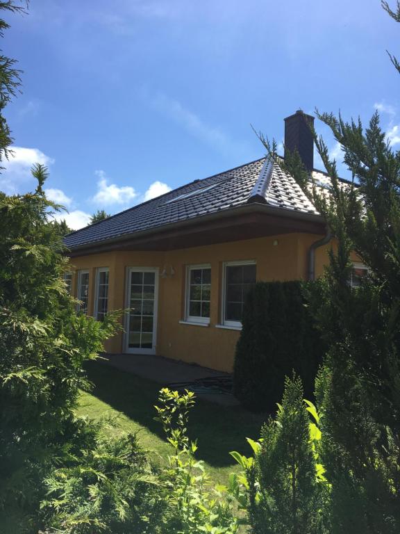 ein kleines gelbes Haus mit einem Dach in der Unterkunft Möllis Apartment am Jasmund-Nationalpark in Lohme