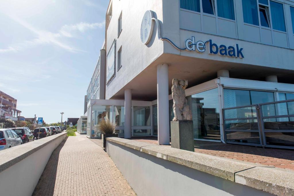 a building with a sign on the side of it at de Baak Seaside in Noordwijk aan Zee