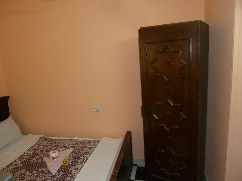a bedroom with a bed and a wooden cabinet at Venus Hostel in Cairo