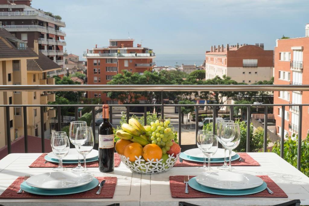 a table with a bowl of fruit and wine glasses at Vilamarlux I in Vilassar de Mar