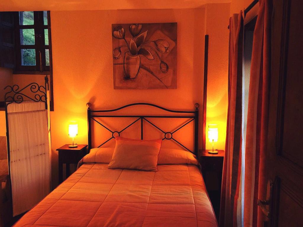Las MorterasにあるApartamentos Rurales Xaranzanaのベッドルーム1室(両側にランプ2つ付)