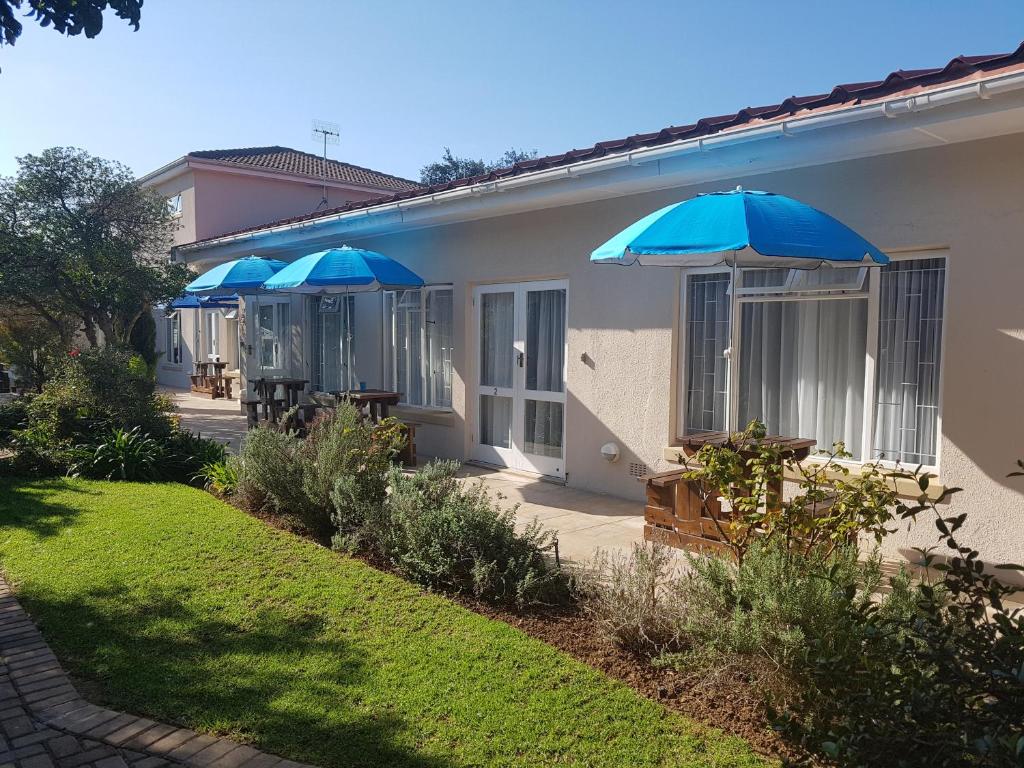 a row of blue umbrellas on the side of a house at 10 Windell Self Catering Accommodation in Durbanville