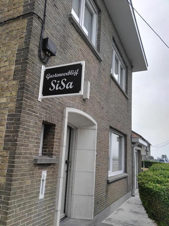 a brick building with a sign that reads siesta at Guesthouse SiSa in Veurne