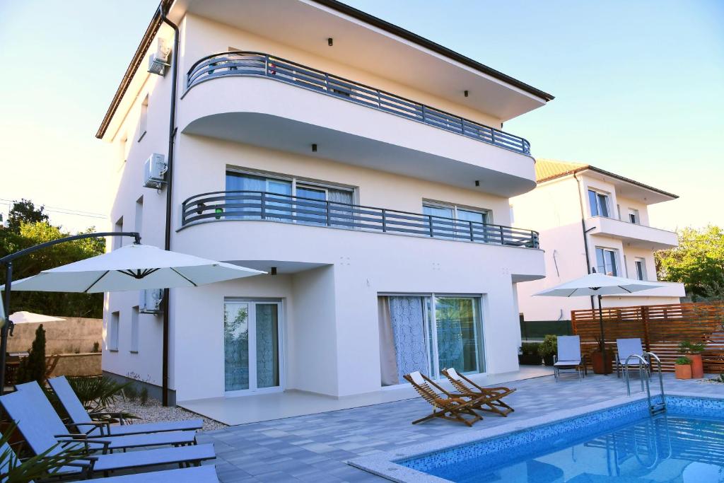 a villa with a swimming pool and a house at Apartmani Valis in Matulji