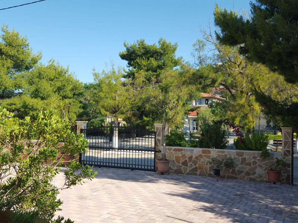 a black iron fence with trees in a park at Cottage Sakkatos in Dhavgáta