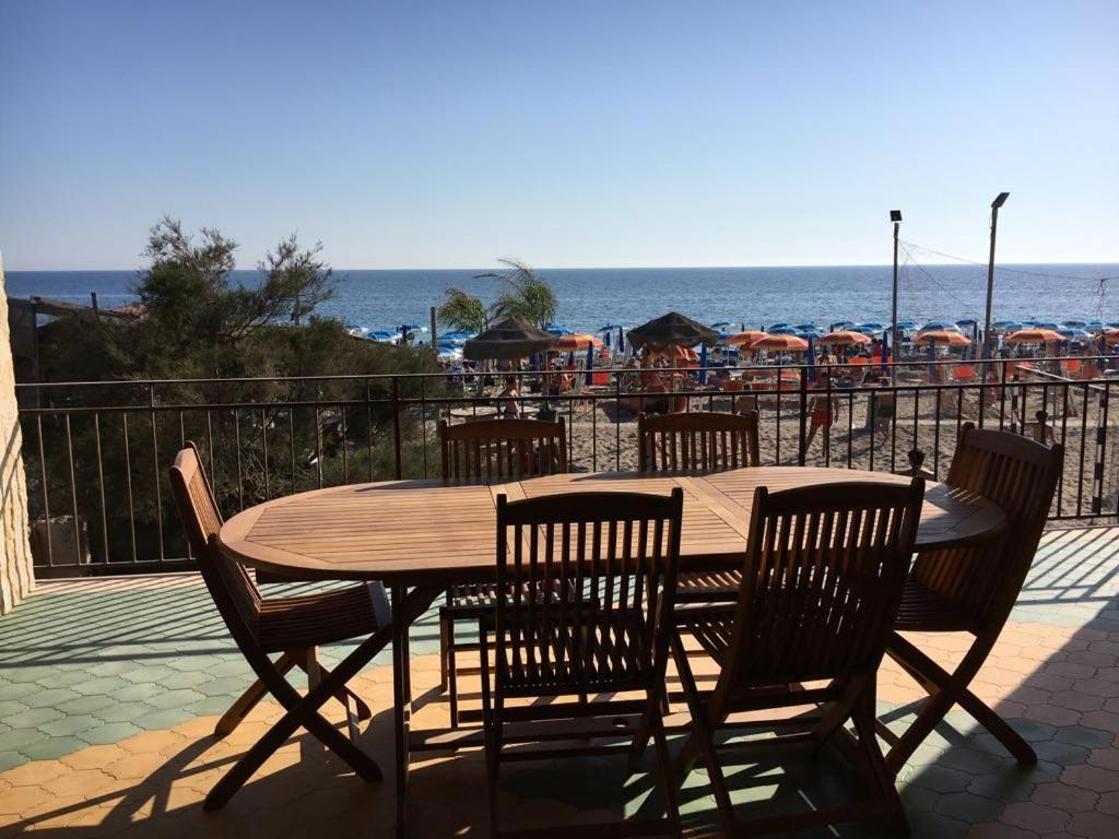 a wooden table and chairs with a view of the beach at Casa Liliana in Marsala