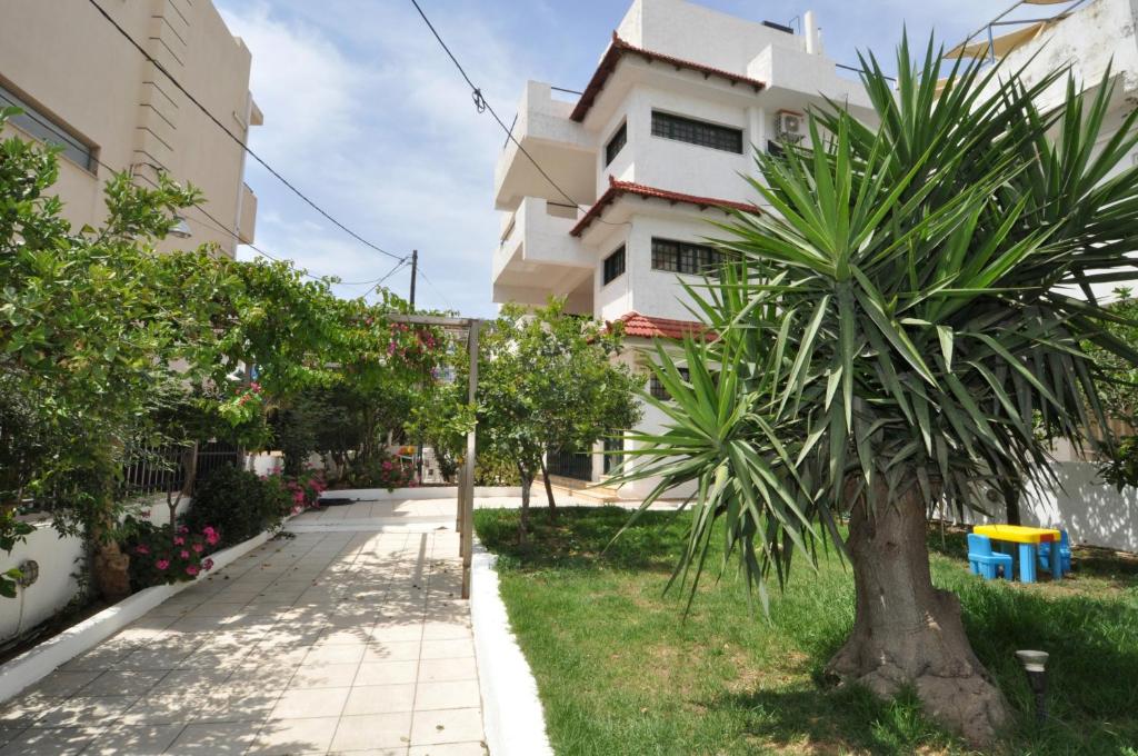 eine Palme vor einem Gebäude in der Unterkunft Ocean Village Apartments in Agia Pelagia