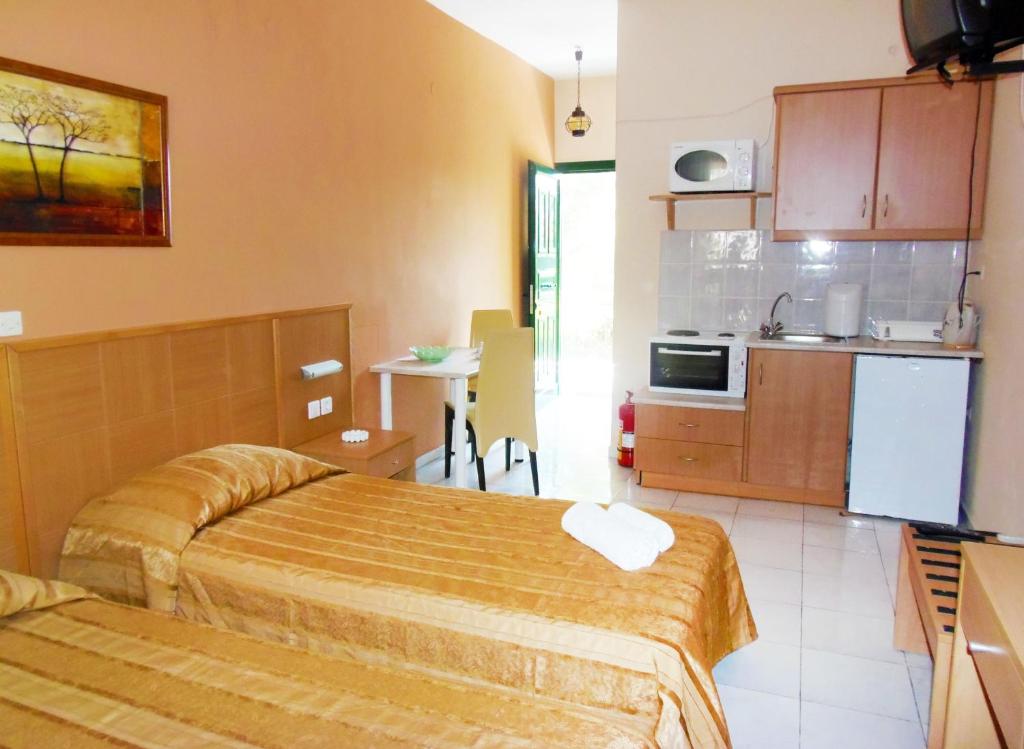 a hotel room with two beds and a kitchen at Synodinos Studios in Lixouri