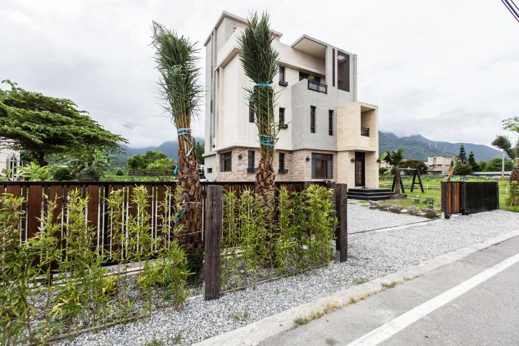 a house with palm trees in front of a fence at Valley Silence B&amp;B in Ji&#39;an