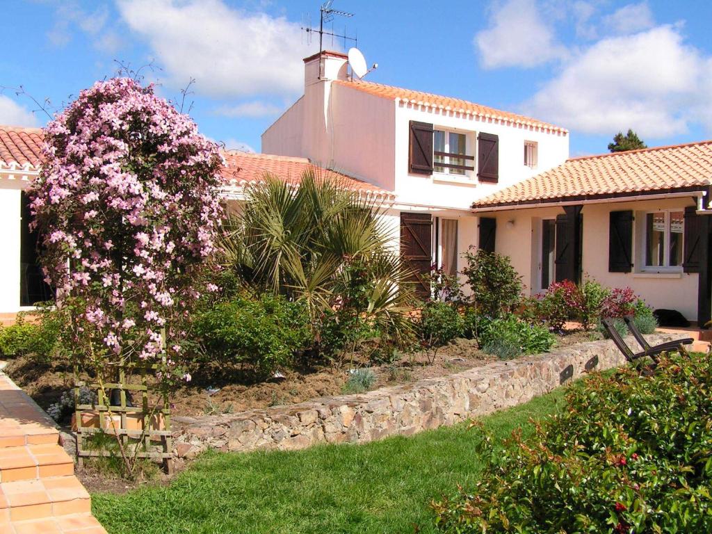 a house with pink flowers in the yard at Chambres d'Hôtes La Forterie in Vairé