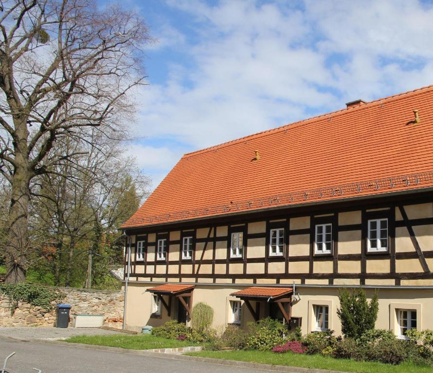 a black and white building with an orange roof at FEWO-im-sanierten-Fachwerkhaus in Müglitztal