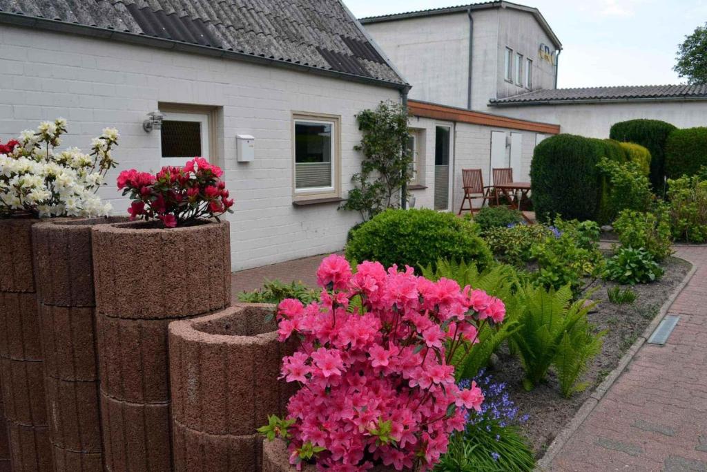 a garden with pink flowers in front of a house at Ferienhaus-Am-Strand-Haus-2 in Eckernförde
