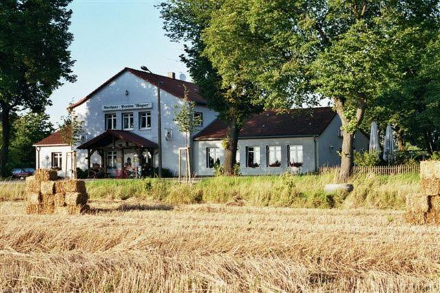 uma casa com um campo de feno à sua frente em Gasthaus Wagner em Golzow