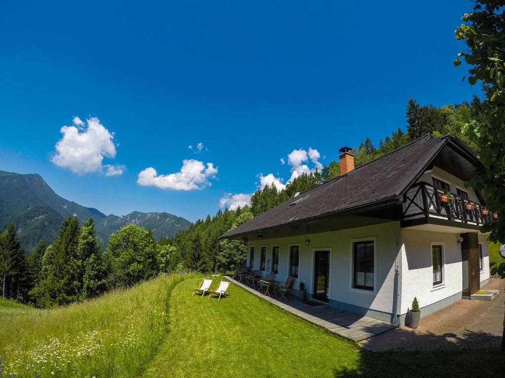 a house on a hill with people sitting on a balcony at Karami Mountainhouse in Tržič